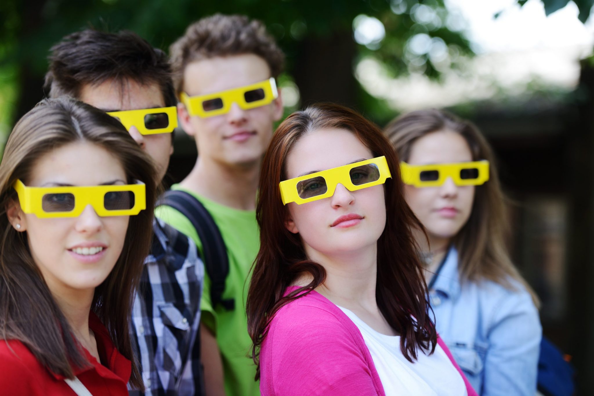 usmívající se mladí lidé nosící 3D brýle z kina